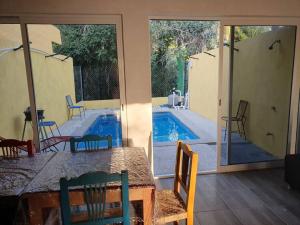 a patio with a table and chairs and a swimming pool at C911 Casa 2 niveles y alberca privada in Peñita de Jaltemba
