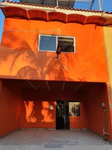 an orange building with a doorway and a window at C911 Casa 2 niveles y alberca privada in Peñita de Jaltemba