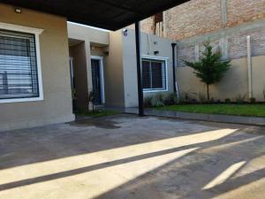 una casa con el sol brillando en un patio en Alquiler Temporario Capitan Bermudez en Ricardone