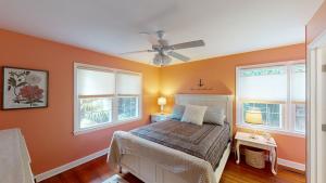 una camera da letto con un letto con pareti e finestre arancioni di CARRIED AWAY home a Jekyll Island