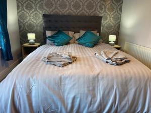 a bed with two robes on it with two lamps at Glenbann House in Coleraine