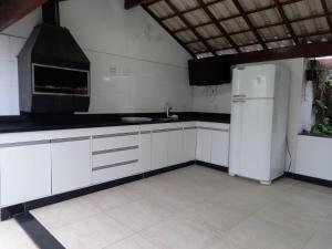 uma cozinha com armários brancos e um frigorífico branco em LUXO E CONFORTO NO CENTRO em Campos dos Goytacazes