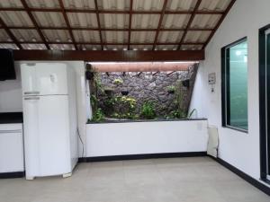 eine Küche mit einem Kühlschrank und einem Aquarium in einer Wand in der Unterkunft LUXO E CONFORTO NO CENTRO in Campos dos Goytacazes