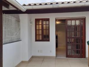 um quarto com paredes brancas e uma porta e janelas em LUXO E CONFORTO NO CENTRO em Campos dos Goytacazes