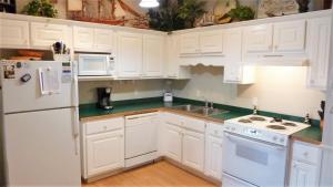 a white kitchen with white appliances and white cabinets at GUIDING LIGHT UNIT C - GROUNDFLOOR apts in Jekyll Island