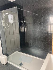 um chuveiro com uma porta de vidro na casa de banho em Glenbann House em Coleraine