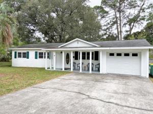 a white house with a car garage at HERON COTTAGE home in Jekyll Island