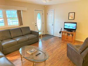 sala de estar con sofá, mesa y TV en HERON COTTAGE home, en Jekyll Island