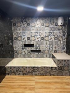 a bathroom with a tub and a tile wall at PANACHE by VG in Lonavala