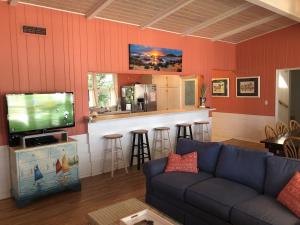 sala de estar con sofá, TV y bar en ISLAND BREEZE home, en Jekyll Island
