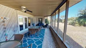 una veranda coperta con tavolo e sedie di AMERICANA BEACH home a Jekyll Island