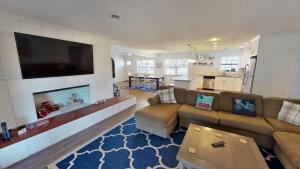 un soggiorno con un divano e una televisione su una parete di AMERICANA BEACH home a Jekyll Island
