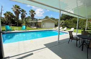 a swimming pool with a table and chairs at THE SALTY SOL home in Jekyll Island