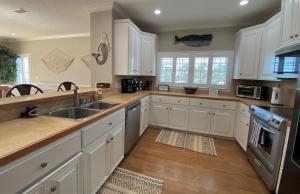 a kitchen with white cabinets and a sink at THE SALTY SOL home in Jekyll Island