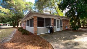 a small brick house with a driveway in front of it at ISLAND PINES home in Jekyll Island
