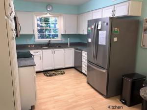 een keuken met een roestvrijstalen koelkast en witte kasten bij A JEKYLL INTERLUDE home in Jekyll Island