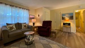 a living room with a couch and a chair at ISLAND PINES home in Jekyll Island
