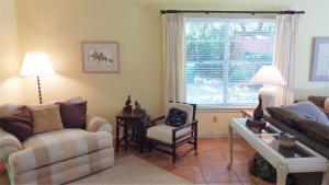 a living room with a couch and a chair and a window at ARIEL EAST DUPLEX Duplex in Jekyll Island +21 photos