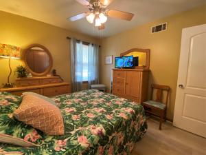 a bedroom with a bed and a ceiling fan and a mirror at HOLLAND HOUSE DUPLEX Duplex in Jekyll Island