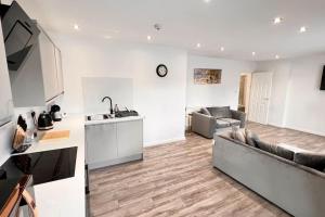 a kitchen and a living room with a couch at Luxury Penthouse in Merseyside, Waterfront in Liverpool