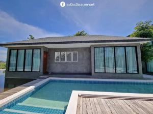 a home with a swimming pool and a house at KEPT Cabana เคปท์ คาบานา in Lampang