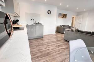 a living room with a couch and a kitchen at Luxury Penthouse in Merseyside, Waterfront in Liverpool