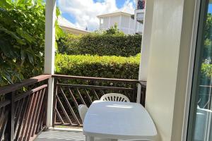 a white chair sitting on a balcony next to a building at Appartement Blue Lagon in Saint-François