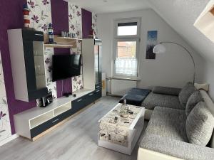 a living room with a couch and a tv at Appartement Plaga in Varel