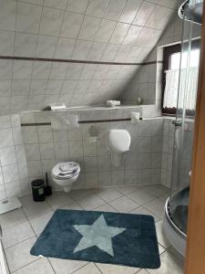 a bathroom with a toilet and a star rug at Appartement Plaga in Varel