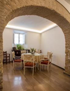 comedor con arco, mesa y sillas en Hotel Tugasa Casa Palacio Medina Sidonia, en Medina Sidonia