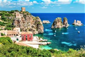 a red building in the middle of a body of water at Casa Vacanza Brigida in Scopello