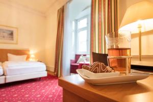 una habitación de hotel con una copa de cerveza y un plato de galletas en Hotel Markgräfler Hof, en Karlsruhe