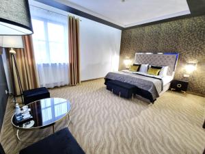 a hotel room with a bed and a table at Hotel Korona Spa & Wellness in Lublin