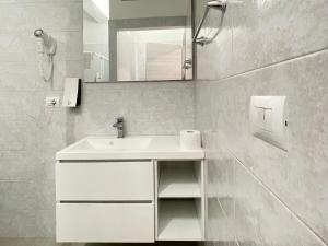 een witte badkamer met een wastafel en een spiegel bij Nuovo Confortini Rooms in Verona