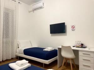 een slaapkamer met een bed, een bureau en een monitor bij Nuovo Confortini Rooms in Verona