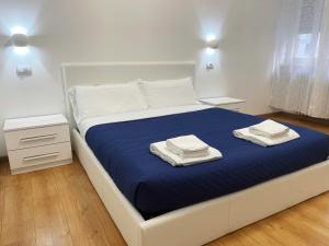 een wit bed met twee handdoeken erop bij Nuovo Confortini Rooms in Verona