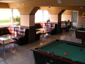 a lobby with a pool table and leather couches at Hotel Naslada in Balchik