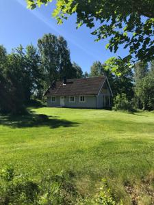 una casa bianca in un campo alberato di Lake and Forest Hideaway a Årjäng