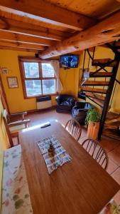 sala de estar con mesa de madera y litera en Alto Rolando Apartamentos en San Carlos de Bariloche