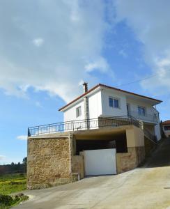 une maison blanche avec garage sur une colline dans l'établissement Casa das Laxas, recién reformada con 5 dormitorios en entorno natural, à Porto do Son