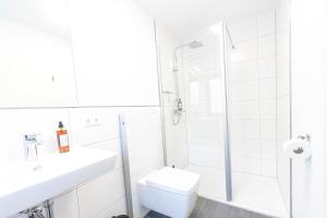 a white bathroom with a shower and a toilet at INhome Design Studio für 2 - Küche - Parkplatz - Netflix in Crailsheim