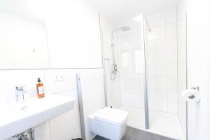 a white bathroom with a shower and a toilet at Business Apartment für 2 - Küche - Parkplatz - Netflix in Crailsheim