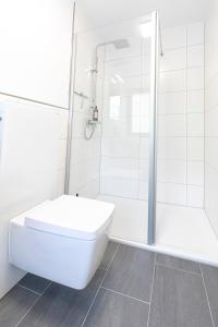 a white bathroom with a toilet and a shower at INhome Design Studio für 2 - Küche - Parkplatz - Netflix in Crailsheim