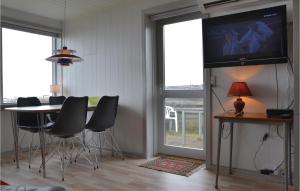 a dining room with a table and a tv on a wall at Beach Front Home In Hundested With Wifi in Hundested