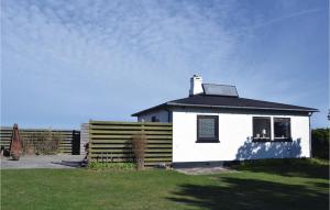 a small white house with a black roof at Beach Front Home In Hundested With Wifi in Hundested