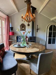 een woonkamer met een tafel en een kroonluchter bij De Schuilhoek Private Guesthouse in Blaricum