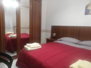 1 dormitorio con cama roja y espejo en Antico Portale - Host Roberto, en Regalbuto