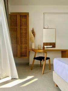 a room with a desk and a table with a mirror at Calistus Mykonos in Mikonos