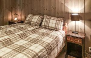 1 cama con manta a cuadros y 2 mesitas de noche en Lovely Home In Tuddal With Jacuzzi, en Tuddal