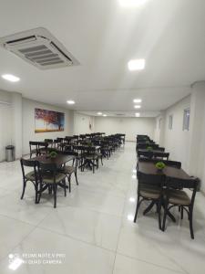 a dining room with tables and chairs in a room at Hotel Serrano in Frederico Westphalen